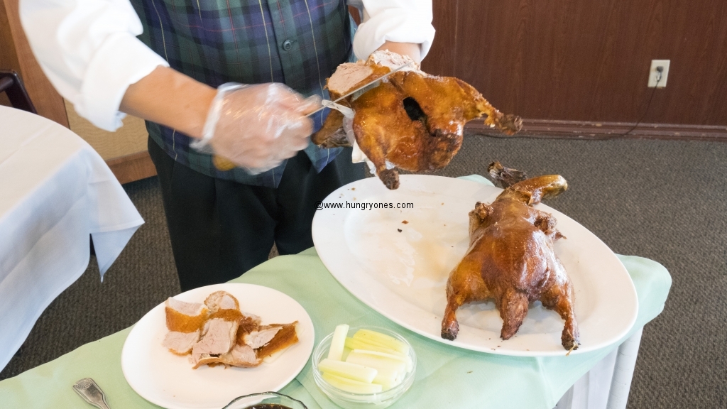 Server cuts off the skin for duck in a bun while the rest will go in a lettuce wrap.